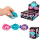 Mano apretando un mini ajolote squishy de color azul turquesa con purpurina brillante de la marca Scrunchems.